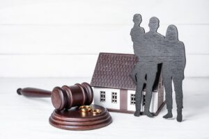 uncontested divorce Benefits Riverside California portrayed by family cutout near gavel and model home.