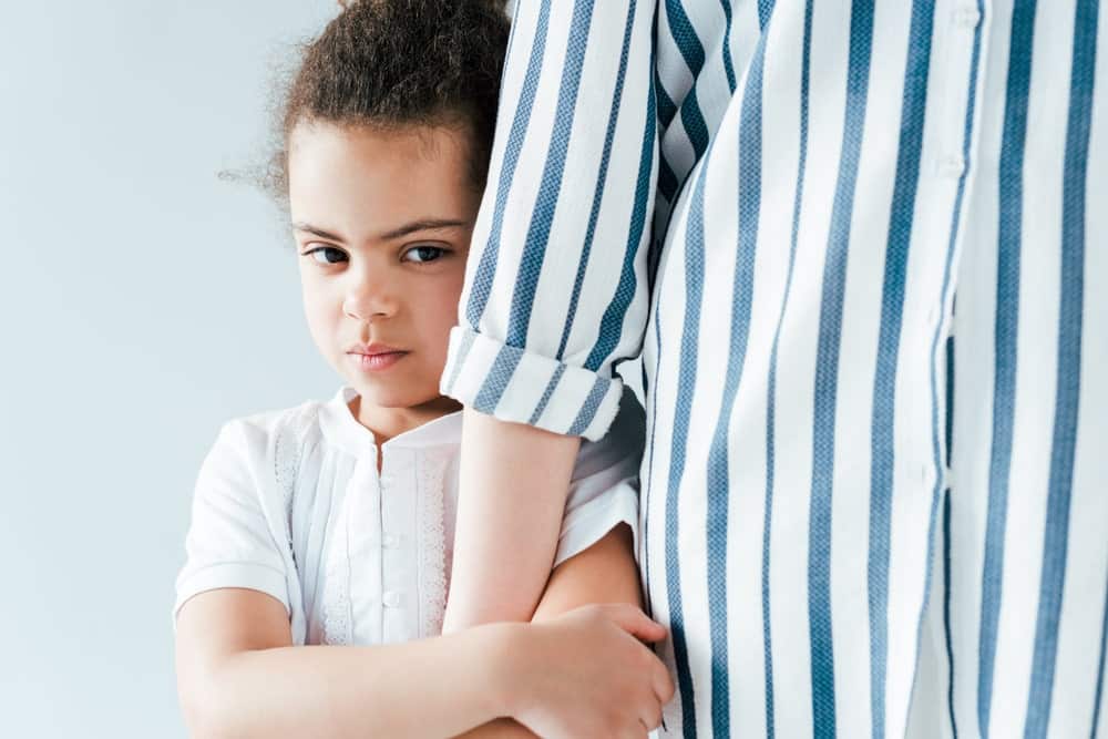 Child Refusing Visitation with a Parent in Los Angeles California portrayed by a child hiding behind her mother.